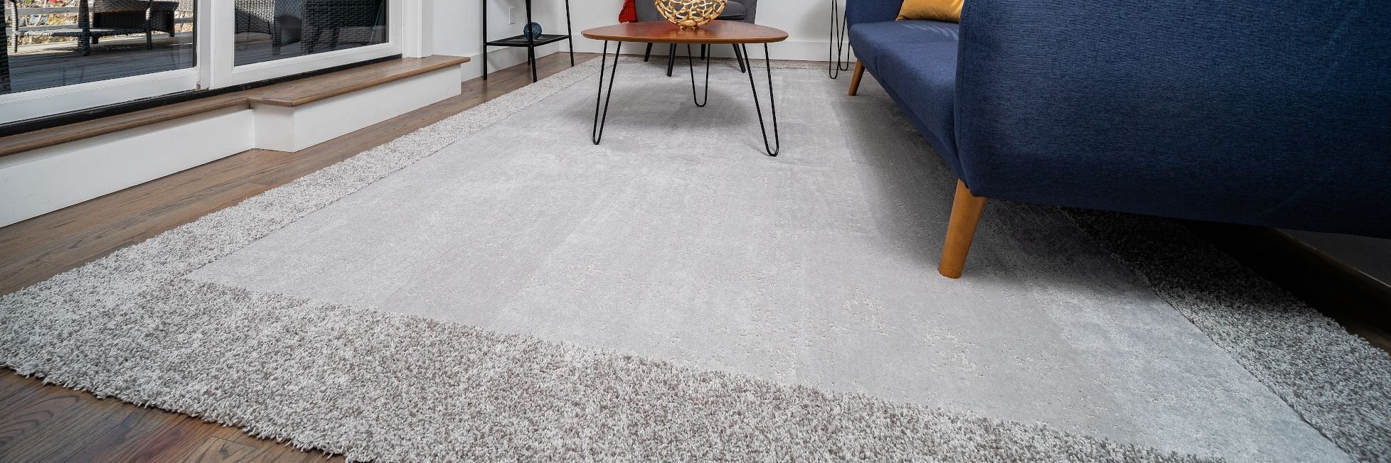 Living room with hardwood flooring and a large gray area rug from Matson Rugs, Inc in Berlin, CT